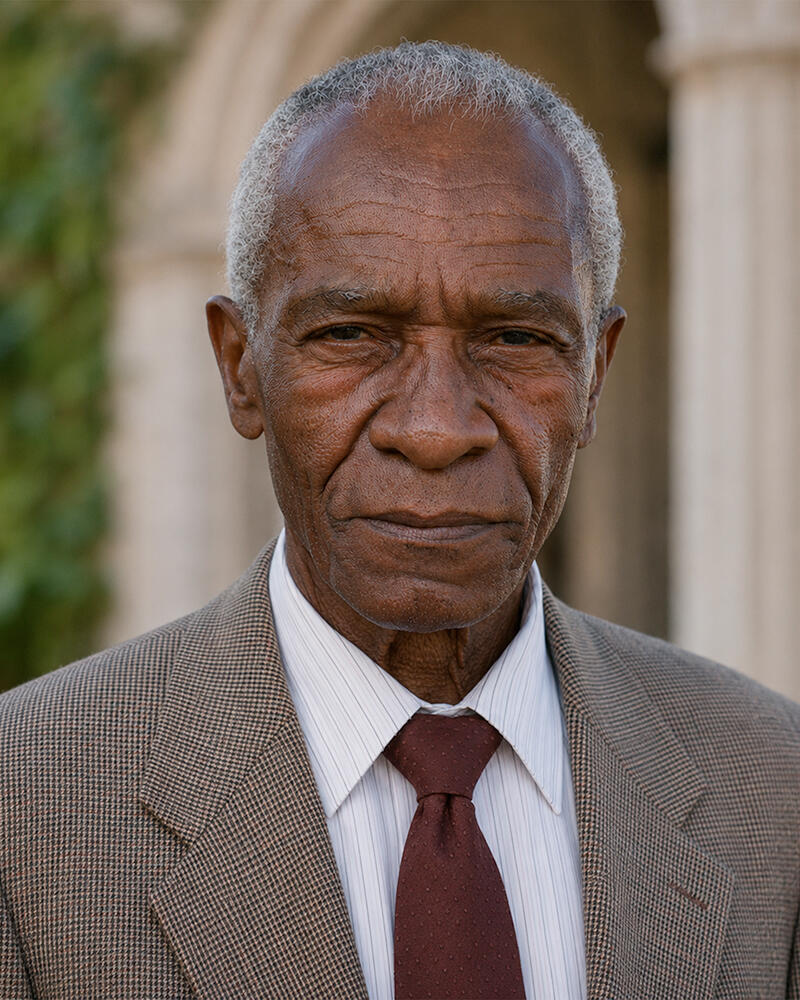 Fictional portrait of Dr. Hannibal Brown, an elderly Black professor with short gray hair, wearing a brown suit and burgundy tie.